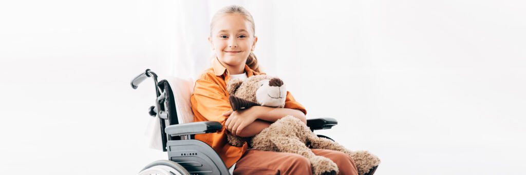 Young Girl Sitting in Wheelchair with Teddy Bear
