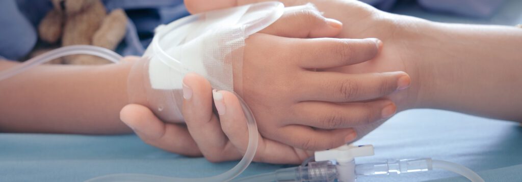 Pediatric patient's hand held with IV unit attached