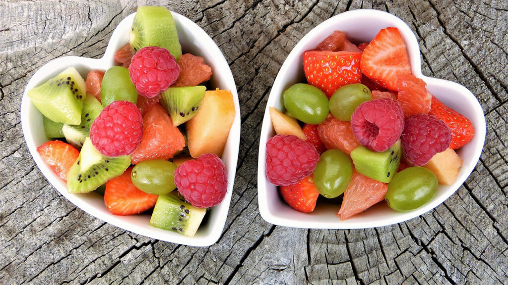 Two heart-shaped bowls filled with nutritious fruits