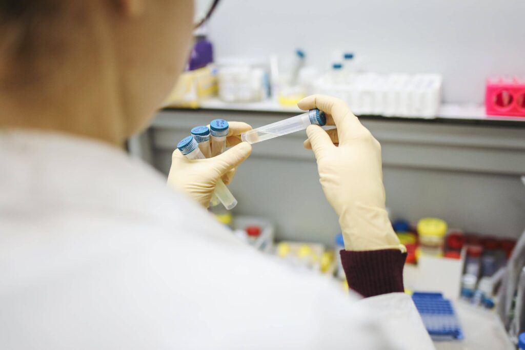 A researcher handling test tubes used in a clinical trial