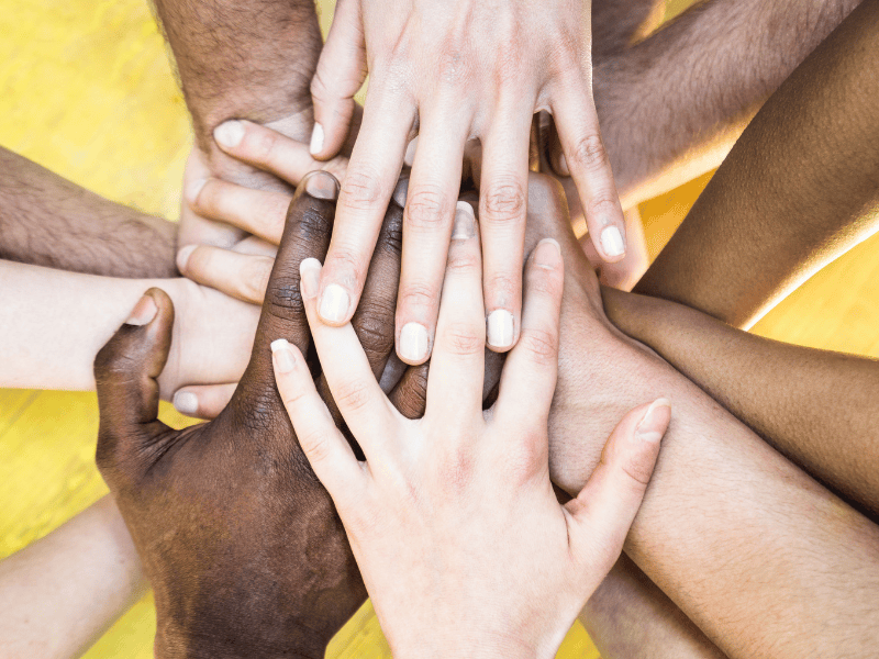 Hands of many different races joined together, representing the fight to end health inequity